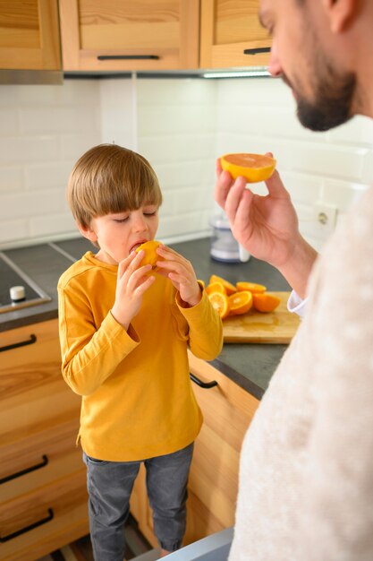 Filho e pai comendo uma laranja
