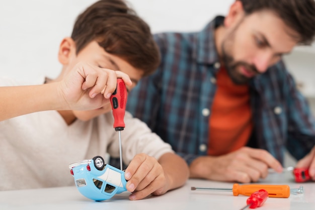Filho e pai consertando carros de brinquedo
