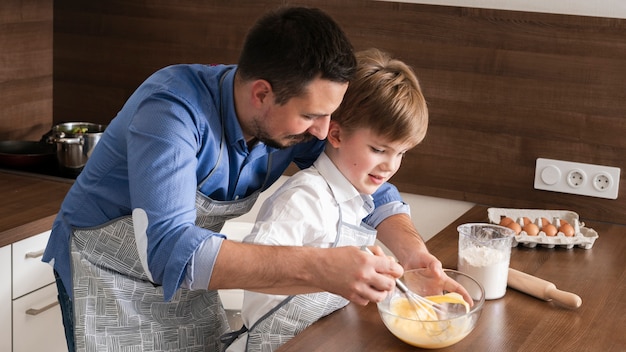 Foto grátis filho e pai de alto ângulo preparando massa