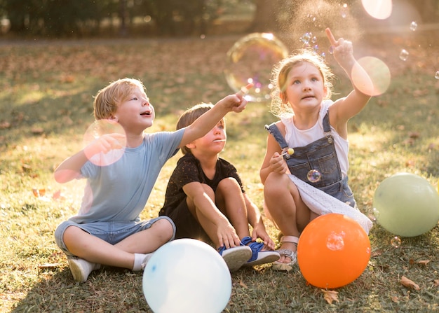 Foto grátis filhos completos brincando ao ar livre