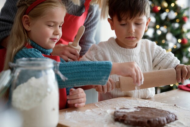 Filhos e mãe preparando massa para biscoitos de gengibre