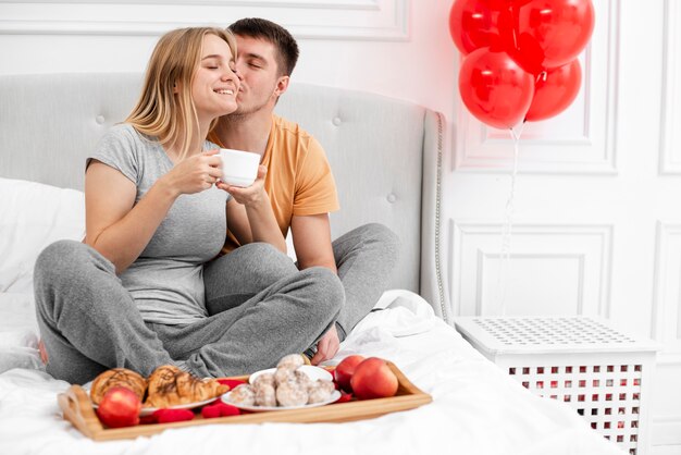 Filmagem completa casal feliz com café da manhã na cama