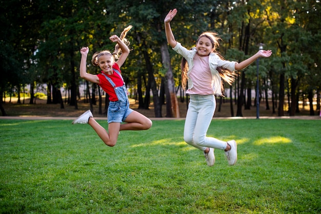 Filmagem completa de meninas pulando ao ar livre