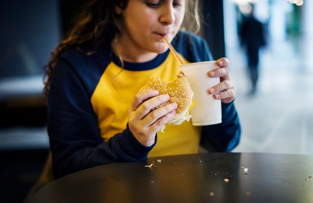 Fim, cima, adolescente, menina, comer, hambúrguer, obesidade, conceito