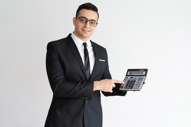 Financista bem sucedido usando calculadora e mostrando para a câmera.