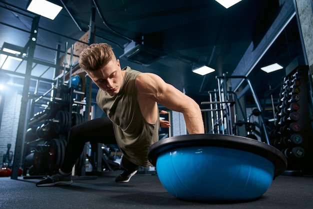 Foto grátis fisiculturista fazendo flexões por um lado