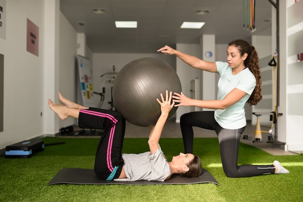 Fisioterapeuta ajudando jovem caucasiana com exercício