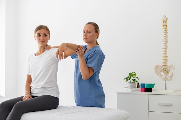 Fisioterapeuta ajudando uma jovem paciente em sua clínica