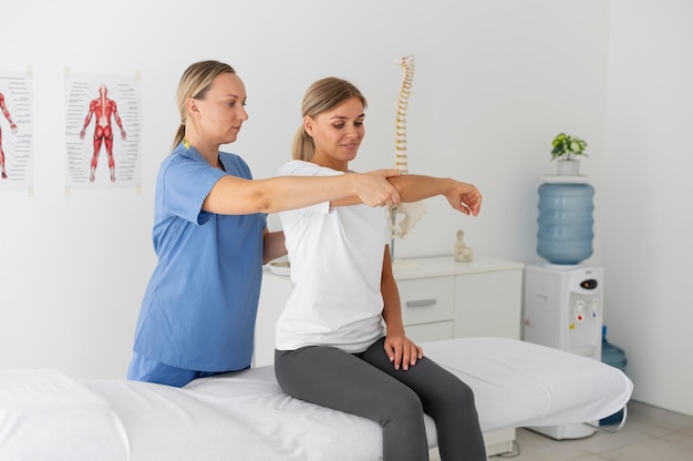 Fisioterapeuta ajudando uma paciente do sexo feminino em sua clínica