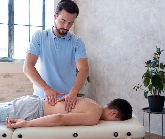 Fisioterapeuta com dose média massageando as costas