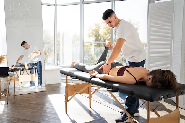 Fisioterapeuta massageando paciente completo