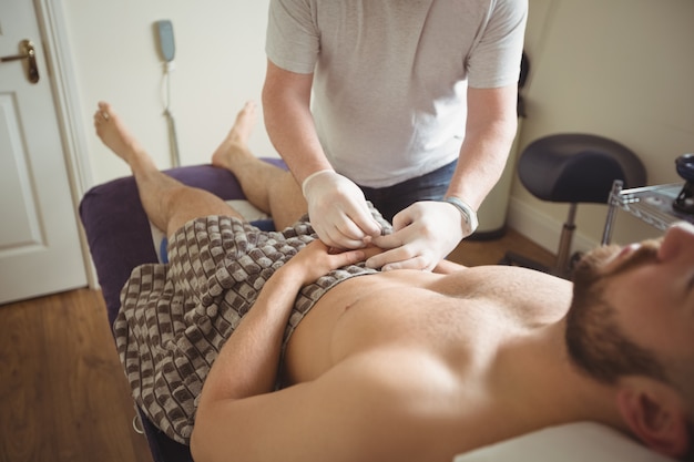 Foto grátis fisioterapeuta realizando agulhamento seco na mão de um paciente