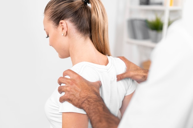 Fisioterapeuta verificando ombros de uma mulher
