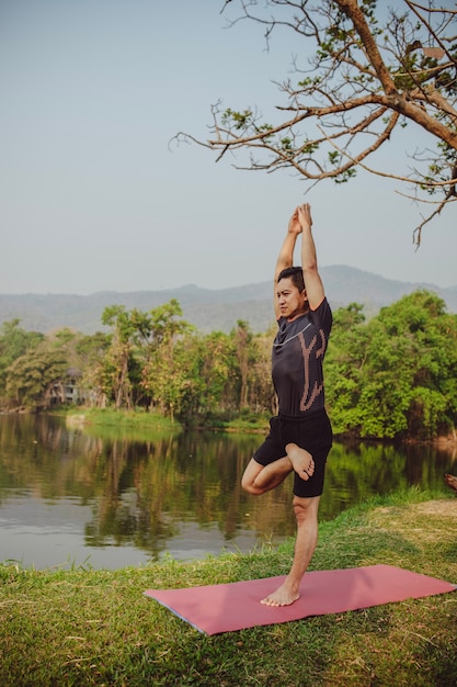 Foto grátis fit homem com ioga pose na natureza