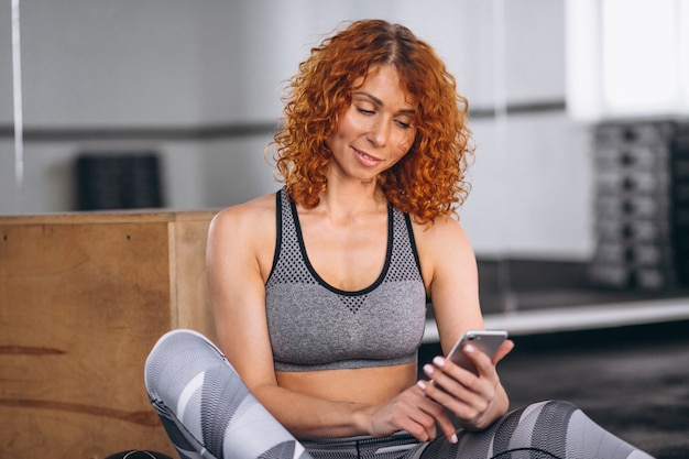 Fitness mulher falando ao telefone no ginásio