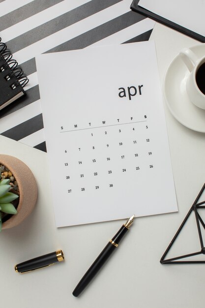 Flat lay calendário de abril e xícara de café
