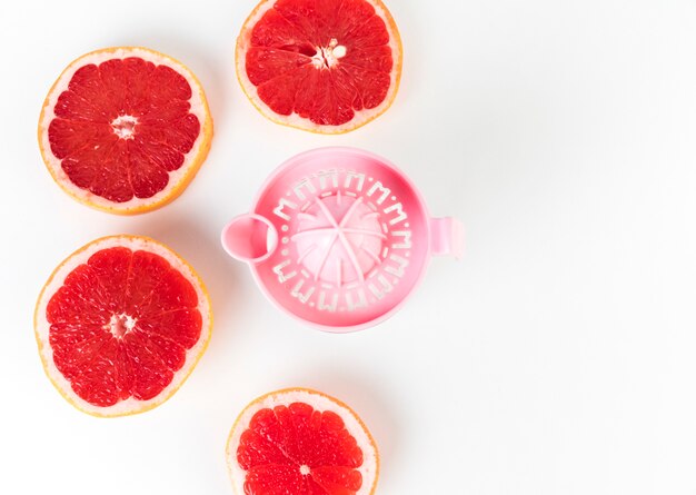 Flat lay juicer e grapefruit em metades