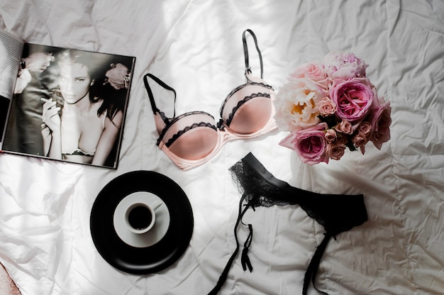 Flat leigos com lingerie de renda preta, buquê de rosas, café e revista