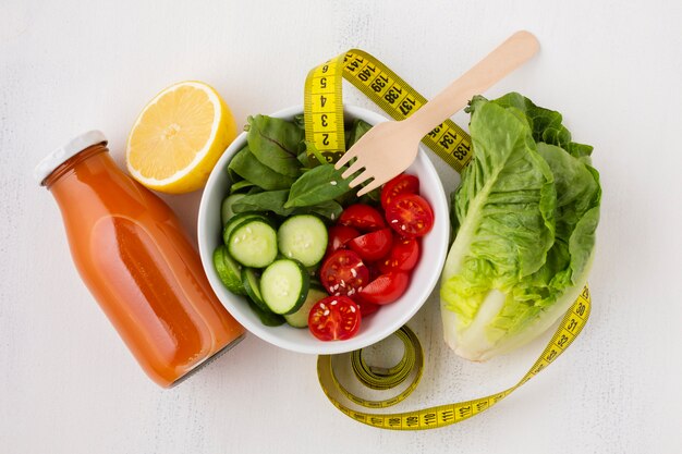 Flat leigos de salada e garrafa de suco