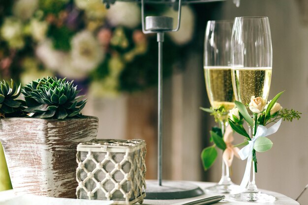 Flautas de champanhe decoradas com pequenas rosas estão na mesa