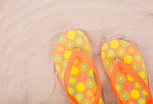 Foto grátis flip-flops na areia da praia