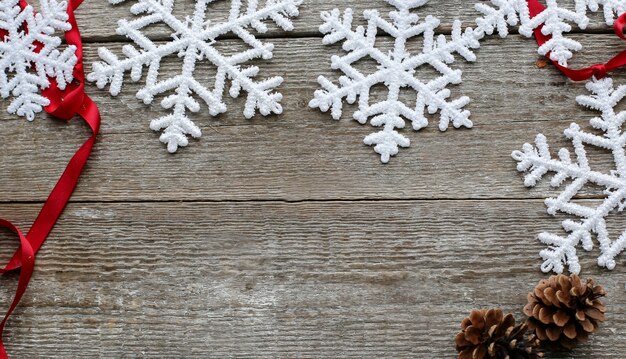 Flocos de neve com pinhas e fita vermelha