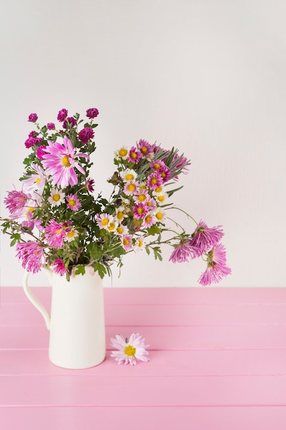 Flores brilhantes em vaso na mesa