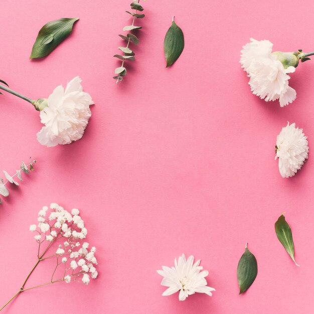 Flores com folhas espalhadas na mesa