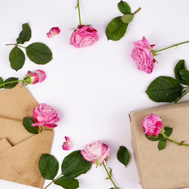 Flores cor de rosa com caixa de presente marrom no fundo branco