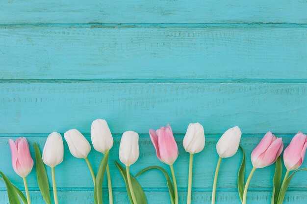 Flores de tulipa brilhante na mesa de madeira