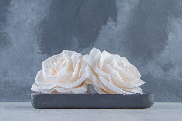 Flores em uma placa de madeira, sobre fundo branco. Foto de alta qualidade