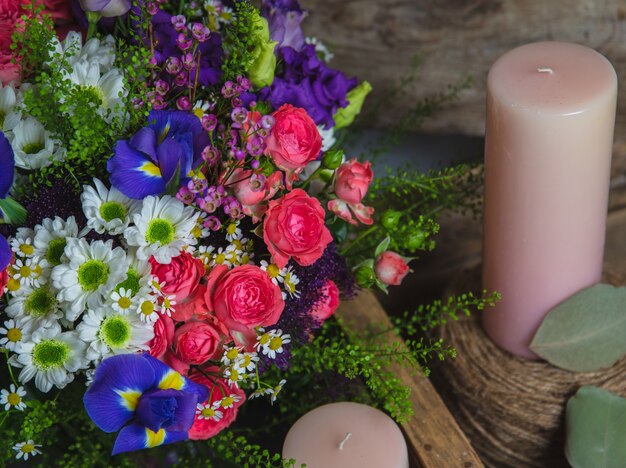 Flores mistas e velas de aroma-de-rosa.