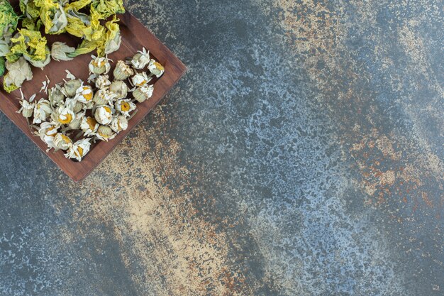 Flores naturais secas na placa de madeira.