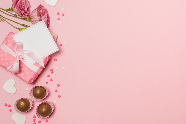 Foto grátis flores perto de cartão postal na caixa de presente e bombons de chocolate