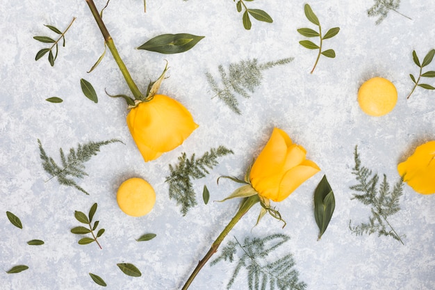 Foto grátis flores rosas com macaroons na mesa cinza