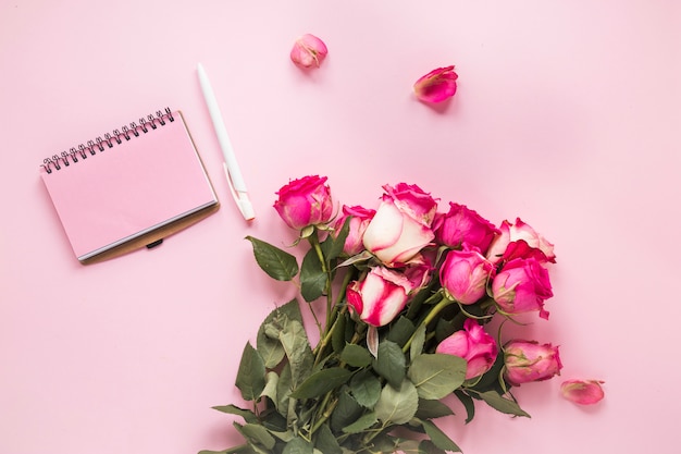 Flores rosas cor de rosa com notebook na mesa