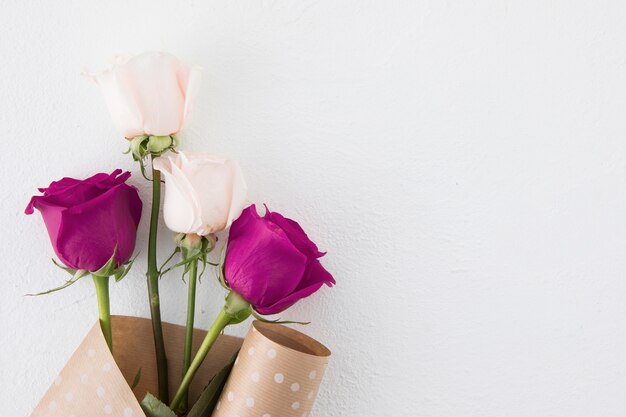 Flores rosas em papel de embalagem na mesa branca