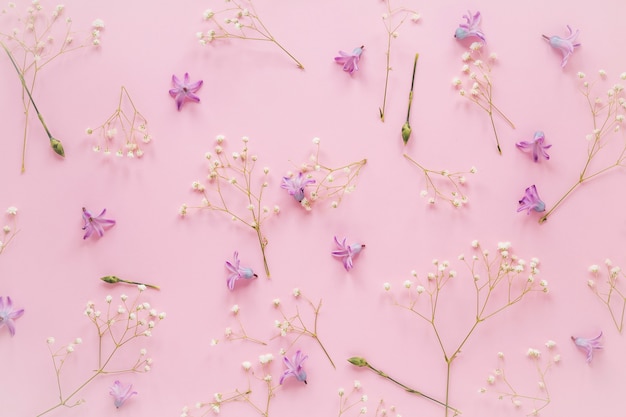 Foto grátis flores roxas com galhos de plantas na mesa
