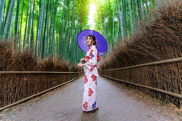 Floresta de bambu. mulher asiática vestindo quimono tradicional japonês na floresta de bambu em kyoto, japão.