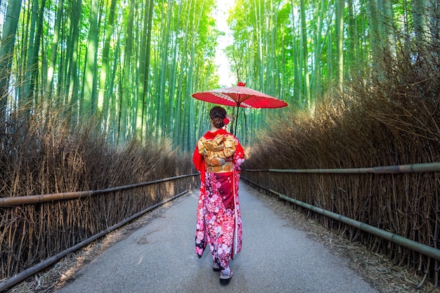 Floresta de bambu. mulher asiática vestindo quimono tradicional japonês na floresta de bambu em kyoto, japão.