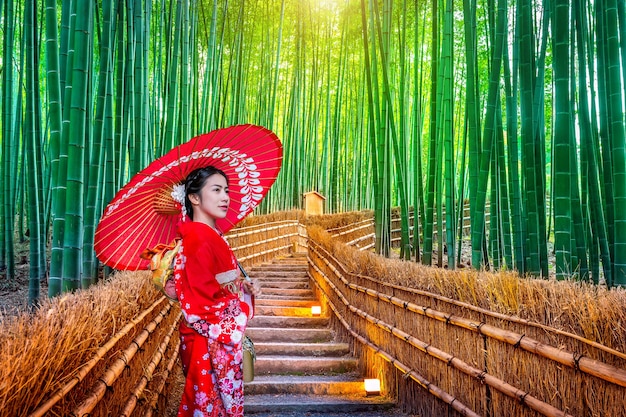 Foto grátis floresta de bambu. mulher asiática vestindo quimono tradicional japonês na floresta de bambu em kyoto, japão.