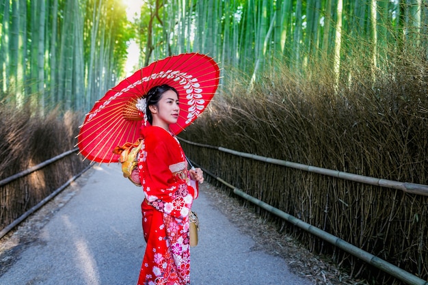 Floresta de bambu. Mulher asiática vestindo quimono tradicional japonês na floresta de bambu em Kyoto, Japão.