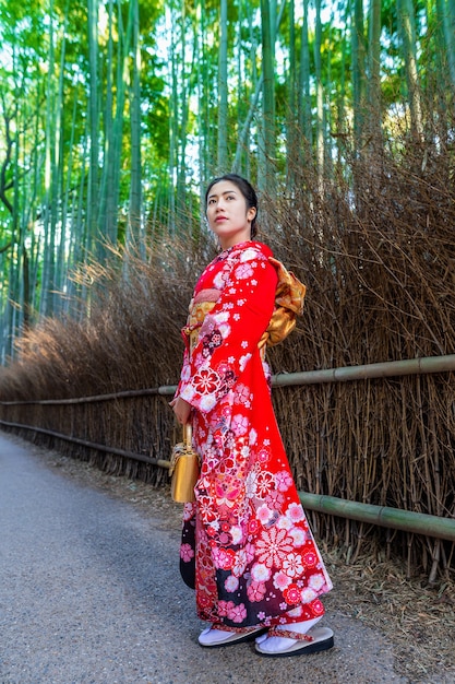 Foto grátis floresta de bambu. mulher asiática vestindo quimono tradicional japonês na floresta de bambu em kyoto, japão.