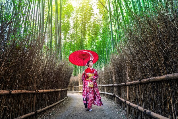 Floresta de bambu. Mulher asiática vestindo quimono tradicional japonês na floresta de bambu em Kyoto, Japão.