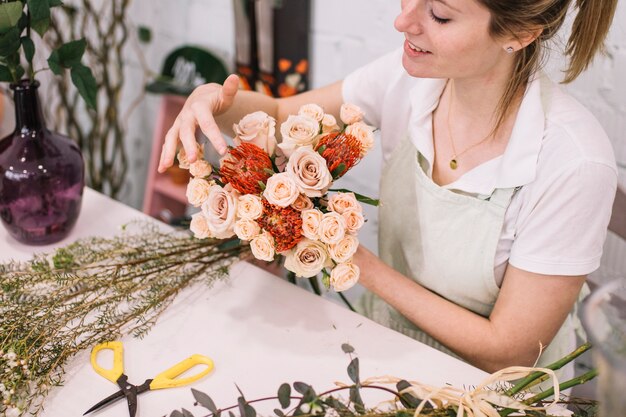 Florista ajustando flores em buquê