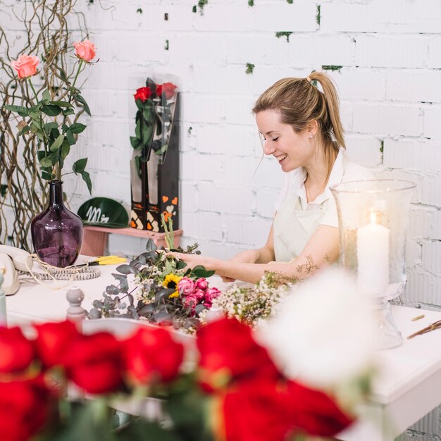 Florista alegre fazendo bouquet