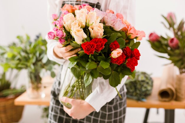 Florista de close-up, segurando o frasco com flores