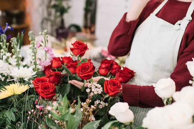 Foto grátis florista de colheita tocando rosas vermelhas