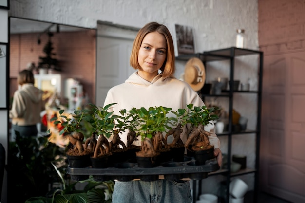 Foto grátis florista de tiro médio com plantas