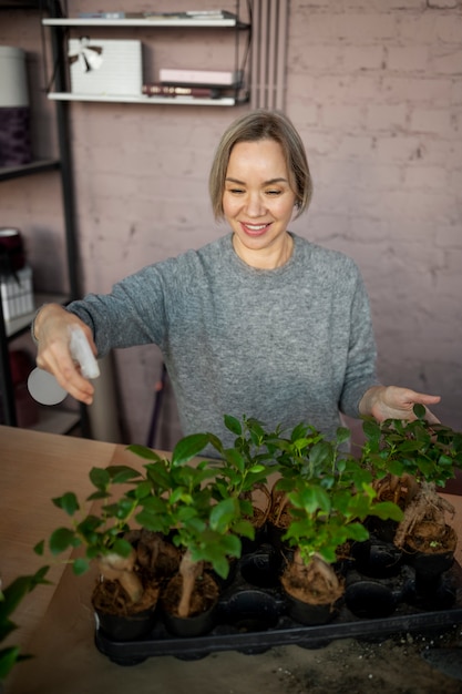 Foto grátis florista de tiro médio regando flores